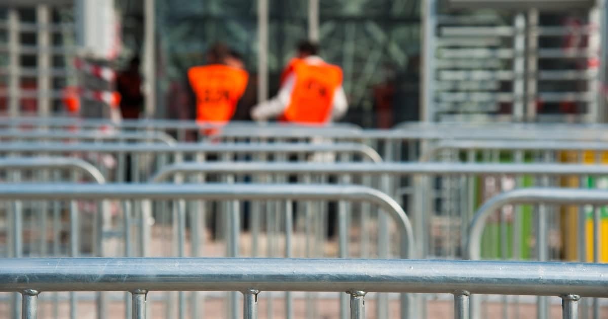 Crowd control barriers set up outside an airport for security.