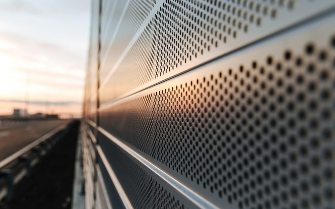 Close-up of perforated metal fencing for privacy and noise reduction.