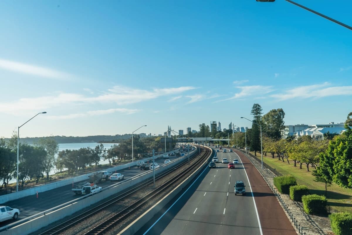 An aerial view of freeway traffic in Perth, Western Australia. The image shows strong traffic barriers installed for road safety.