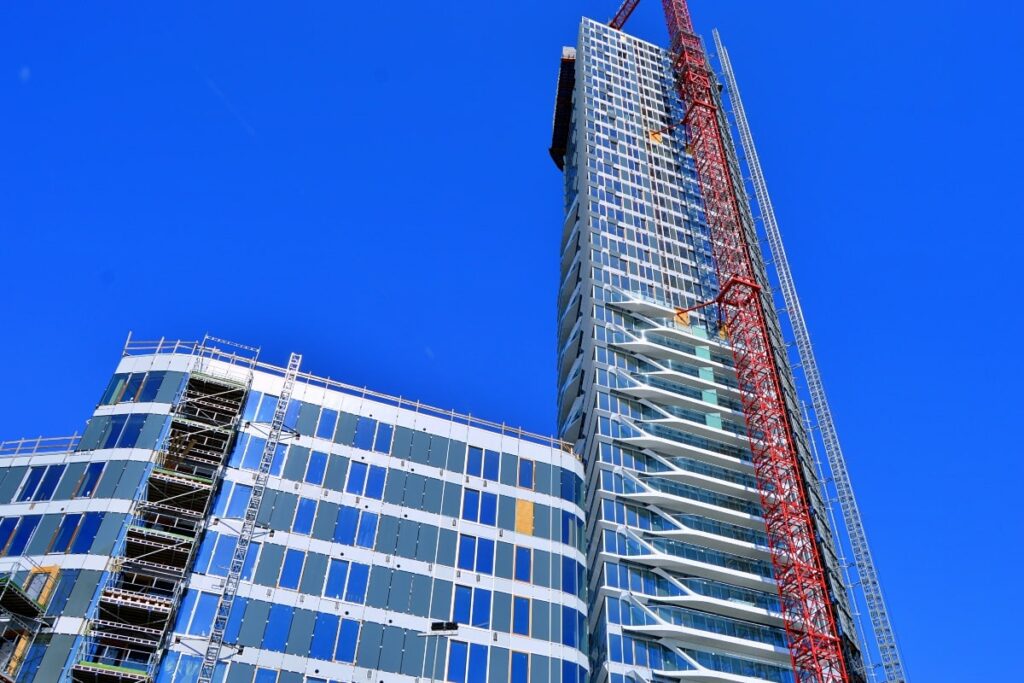 Mast scaffolding extending alongside a modern skyscraper, illustrating its effectiveness in vertical projects.