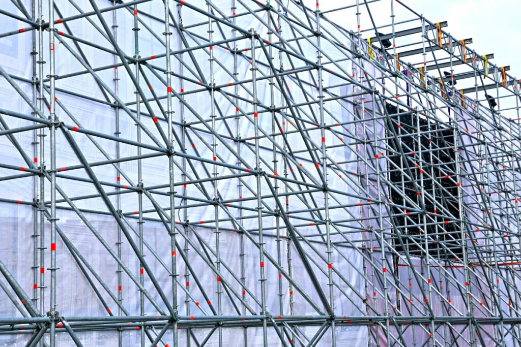 Complex network of modular scaffolding covering a building under renovation, demonstrating its capability to conform to diverse architectural shapes and sizes.