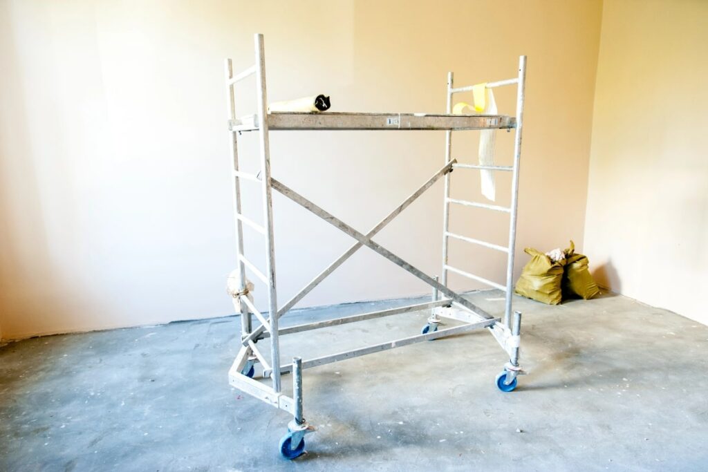 Mobile scaffolding setup inside a bright room with no visible workers, illustrating the portability and convenience of this scaffolding type for indoor construction tasks.