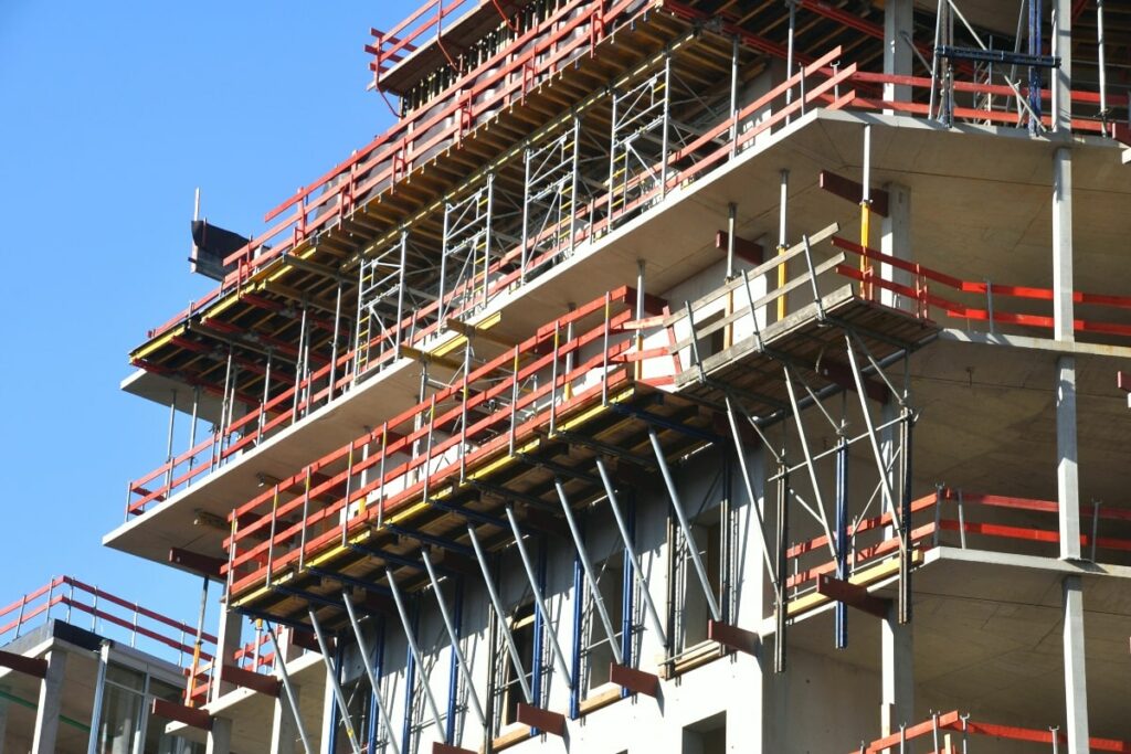 Cantilever scaffolding system supporting construction on the outer levels of a high-rise building, demonstrating its utility for overhanging structures.