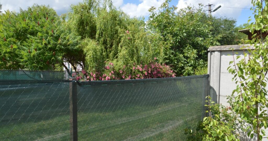 Temporary privacy fencing with shade cloth in a garden setting, showing how renters can create a private outdoor space.